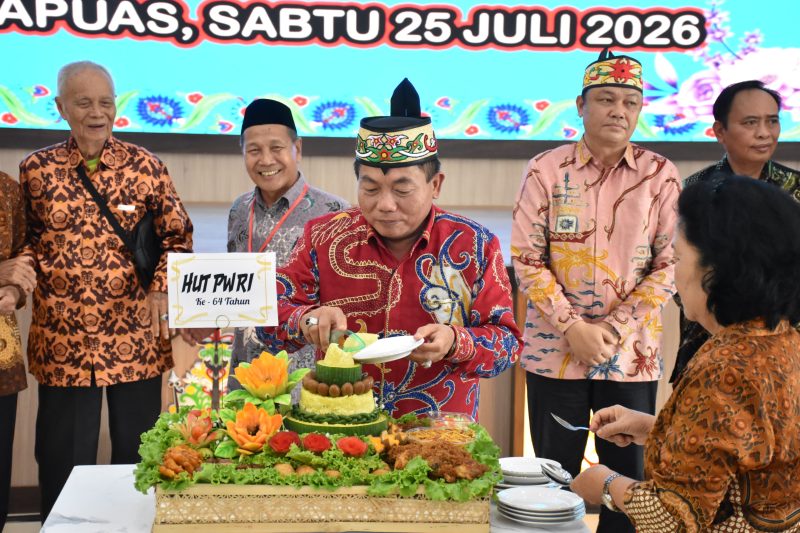 Bupati Kapuas, H.M. Wiyatno, melakukan pemotongan tumpeng sebagai simbolis perayaan HUT ke64 PWRI Kabupaten Kapuas Tahun 2026, di Aula Kantor Bupati Kapuas, Sabtu (25/7/2026). 