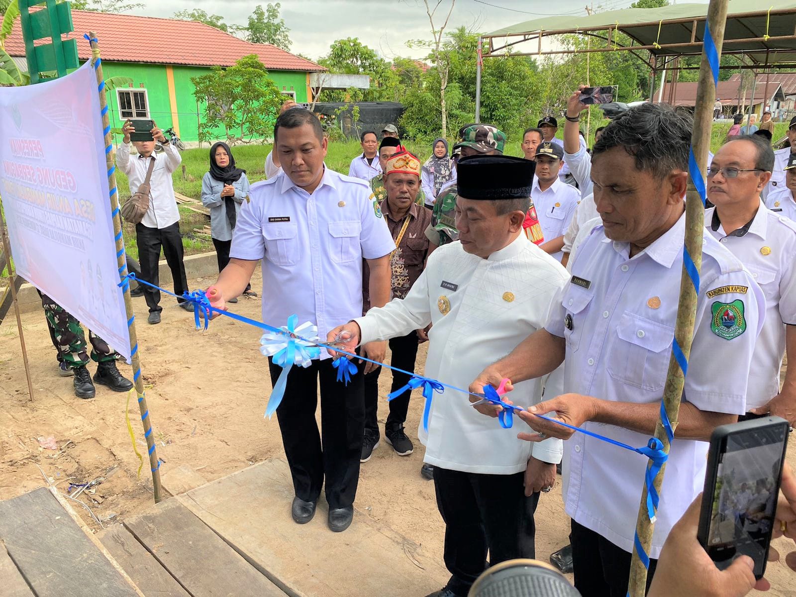 Bupati Kapuas HM Wiyatno saat melakukan pemotongan pita sebagai tanda diresmikannya Gedung Serbaguna Desa Anjir Mambulau Barat, Kecamatan Kapuas Timur, Rabu (12/11/2025).