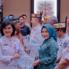 Ketua TP PKK Kabupaten Kapuas Hj. Siti Saniah Wiyatno saat menerima penghargaan kepada pemerintah kabupaten/kota se-Kalimantan Tengah yang telah menyelesaikan dokumen Peta Jalan Pembangunan Kependudukan (PJPK) 2025–2029 serta penilaian kinerja stunting tahun 2025, di Aula Jayang Tingang Kantor Gubernur Kalimantan Tengah, Rabu (29/4/2026).
