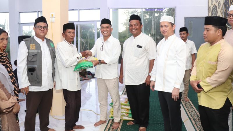 Staf Ahli Bupati Kapuas Budi Kurniawan menyerahkan bantuan beras kepada masyarakat pada kegiatan buka puasa bersama di Masjid Al-Mila, Desa Pulau Telo Baru, Minggu (15/3/2026) sore.