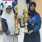 Yumna (kanan) dan Avika saat menerima piala juara Olimpiade Olahraga Siswa Nasional (O2SN) pada ajang Pencak Silat dan Panjat Tebing Tingkat Kabupaten Kapuas
