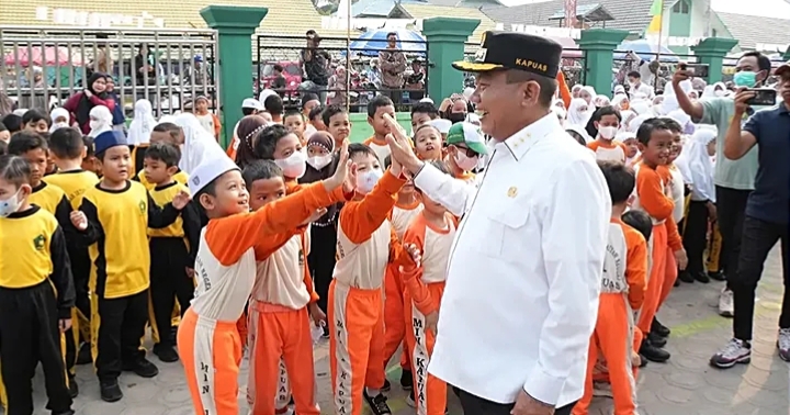 Bupati Kapuas HM Wiyatno bercengkrama dengan anak-anak murid MIN 1 Kapuas Unit 2, di sela kegiatan pembagian masker gratis, Jumat (4/9/2026) pagi